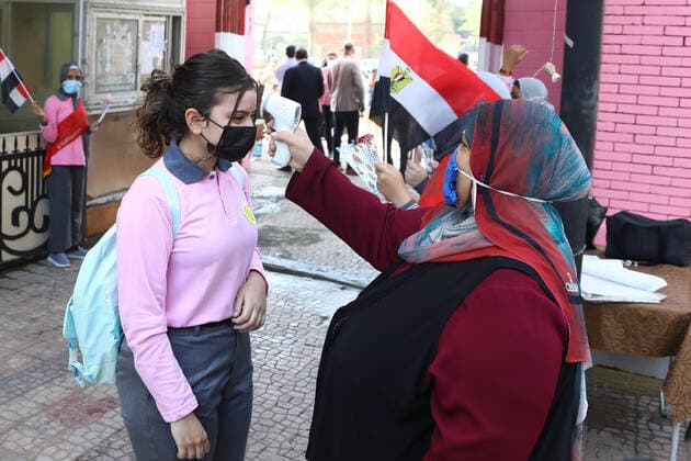 News Bilder des Tages (211010) -- CAIRO, Oct. 10, 2021 -- A student has her temperature checked before entering a middle school opened following months of closure due to COVID-19 in Cairo, Egypt, Oct. 10, 2021. Millions of school and university students began physically attending classes for the first time in 18 months starting Saturday in Egypt. Schools and universities have launched health awareness campaigns to urge students, teaching staff, and workers to adhere to all precautions against COVID-19, including maintaining physical distance and wearing face masks. ) EGYPT-CAIRO-STUDENTS-RETURN TO SCHOOL AhmedxGomaa 