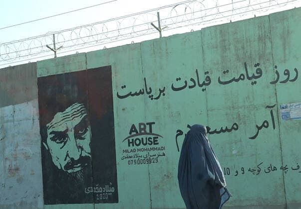 Frauen unter dem Taliban Regime in Afghanistan KABUL, AFGHANISTAN - OCTOBER 4, 2021: A woman passes by a mural of Ahmad Shah Massoud (1953-2001), an Afghan military commander. On August 15, the Taliban forces entered Kabul without any resistance from the government, President Ashraf Ghani fleeing the country. On September 6, the Taliban stated they had established control over the whole territory of the republic. A day later, new government members were revealed to include solely Taliban representatives and be mostly Pashtun, the largest ethnic group in Afghanistan. Alexandra Kovalskaya TASS  TS113F9F