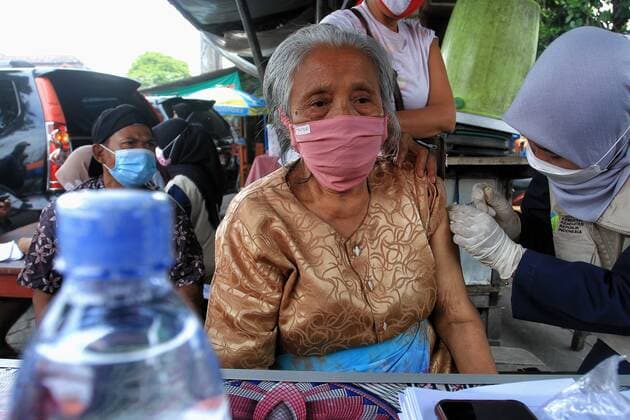Covid-19 Vaccination In Indonesia A health worker inject of the Sinovac Covid-19 vaccine into a street vendors during a vaccination program at the Beringharjo Market in Yogyakarta, Indonesia, on October 14, 2021. Indonesia has inoculated over 100 million people so far, the most in Southeast Asia, is also possible on the prepare reopening tourism for foreign tourists amid the Covid-19 pandemic. (Photo by Devi Rahman INA Photo Agency Sipa USA) 