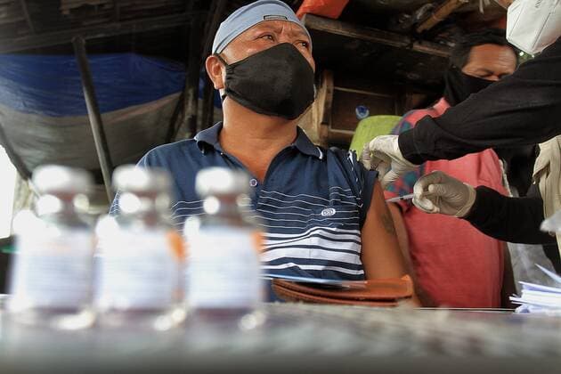 Covid-19 Vaccination In Indonesia A health worker inject of the Sinovac Covid-19 vaccine into a street vendors during a vaccination program at the Beringharjo Market in Yogyakarta, Indonesia, on October 14, 2021. Indonesia has inoculated over 100 million people so far, the most in Southeast Asia, is also possible on the prepare reopening tourism for foreign tourists amid the Covid-19 pandemic. (Photo by Devi Rahman INA Photo Agency Sipa USA) 