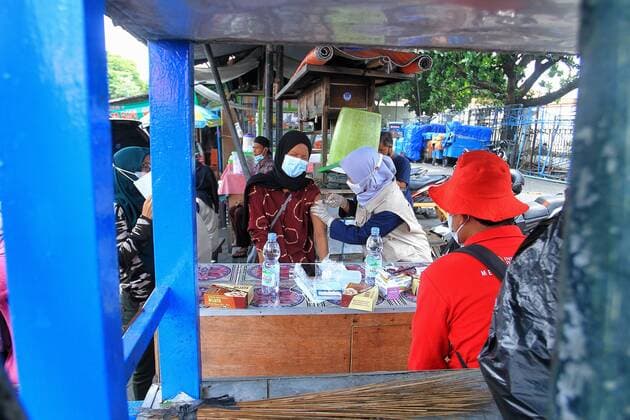 Covid-19 Vaccination In Indonesia A health worker inject of the Sinovac Covid-19 vaccine into a street vendors during a vaccination program at the Beringharjo Market in Yogyakarta, Indonesia, on October 14, 2021. Indonesia has inoculated over 100 million people so far, the most in Southeast Asia, is also possible on the prepare reopening tourism for foreign tourists amid the Covid-19 pandemic. (Photo by Devi Rahman INA Photo Agency Sipa USA) 