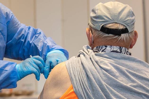 Vaccination team in action A nurse from a mobile vaccination team vaccinates an elderly man in a sports hall in Pirna, Saxony The offer is also intended to reach people who have not previously been vaccinated or who want to take advantage of this opportunity as a booster vaccination Pirna Saxony Germany Daniel Schäfer