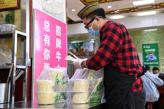 (211022) -- LANZHOU, Oct. 22, 2021 -- A restaurant staff member packs up take-away beef noodles for COVID-19 prevention and control volunteers at a beef noodle restaurant in Lanzhou, northwest China s Gansu Province, Oct. 22, 2021. As new locally transmitted COVID-19 confirmed cases were reported in Lanzhou, some noodle restaurants launched a care campaign which provides free food to frontline essential workers including medical staff and volunteers. ) CHINA-GANSU-LANZHOU-COVID-19-ESSENTIAL WORKERS-FREE FOOD (CN) FanxPeishen 
