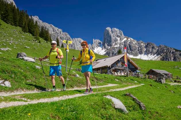 Mature male and female friends hiking at Stuhlalm Hutte on mountain during vacations model released Symbolfoto ANSF00033