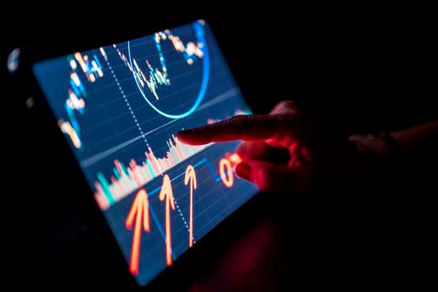 IMAGO Creative: Corporate: Klimaschutz, Digitalisierung und Urbanisierung Businesswoman pointing at stock market data on digital tablet model released Symbolfoto property released DLTSF02230