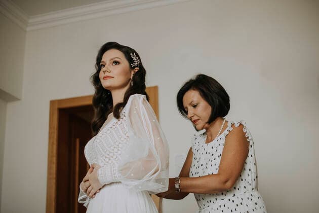 IMAGO Creative: Mutterschaft Mother helping daughter getting dressed for wedding at home model released Symbolfoto property released SSGF00003