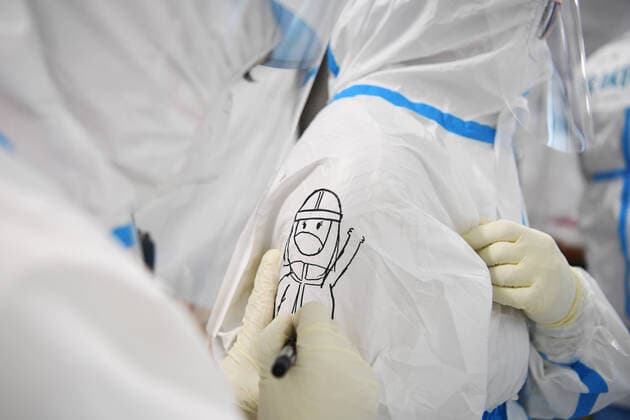 (211024) -- LANZHOU, Oct. 24, 2021 -- A medical worker paints on the protective suit of her colleague at a Falcon air-inflated testing lab for COVID-19 nucleic acid testing in Lanzhou, northwest China s Gansu Province, Oct. 24, 2021. A set of Falcon air-inflated testing lab has been built in Lanzhou for massive nucleic acid tests. The lab is capable of screening up to 800,000 people every day using the ten-in-one mixed testing approach, which greatly improved the testing capabilitiy after the recent resurgence of COVID-19 cases in the city. ) CHINA-GANSU-LANZHOU-COVID-19-TESTING LAB (CN) ChenxBin 