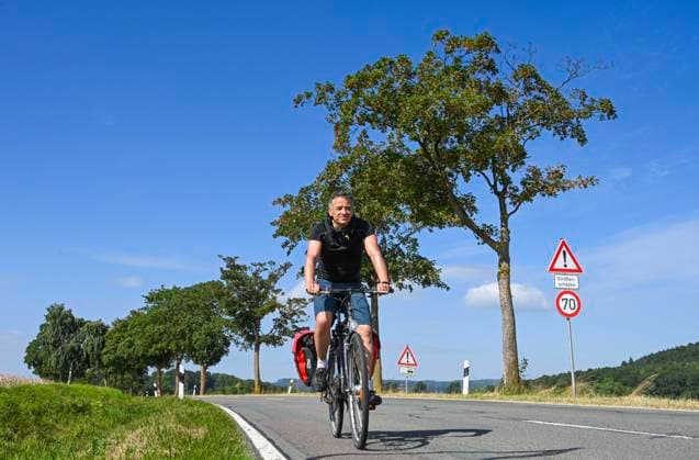 Cyclist, country road near Bad Pyrmont, Weserbergland, Lower Saxony, Germany