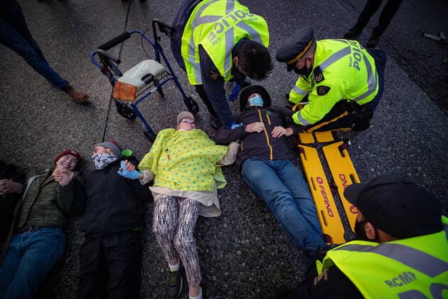 October 25, 2021, Richmond, BC, Canada: RCMP officers use a spinal board to take a person into custody after the environmental activist group Extinction Rebellion blocked the main road used to access Vancouver International Airport, in Richmond, B.C., Monday, Oct. 25, 2021. More than a dozen people were arrested and traffic to and from the airport was diverted due to the protest which was part of the group s two week October Rebellion action. Richmond Canada  - ZUMAc35_ 20211025_zaf_c35_124 Copyright: xDarrylxDyckx