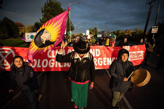 October 25, 2021, Richmond, BC, Canada: A person carries a women s warrior flag as the environmental activist group Extinction Rebellion marches before blocking the main road used to access Vancouver International Airport, in Richmond, B.C., Monday, Oct. 25, 2021. More than a dozen people were arrested and traffic to and from the airport was diverted due to the protest which was part of the group s two week October Rebellion action. Richmond Canada  - ZUMAc35_ 20211025_zaf_c35_148 Copyright: xDarrylxDyckx