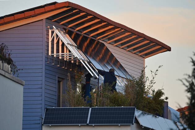 IMAGO Nature: Unsere Erde, Energiequellen, Photovoltaik Einfamilienhaus mit Photovoltaikanlage:Ein Monteur bei der Montage von Solarpanels an einem Hausgiebel. Solarzellen,Solarmodule auf dem Dach eines Wohnhauses. Solarstrom,Solarenergie *** Single-family house with photovoltaic system A fitter installing solar panels on a house gable Solar cells,solar modules on the roof of a residential house Solar power,solar energy