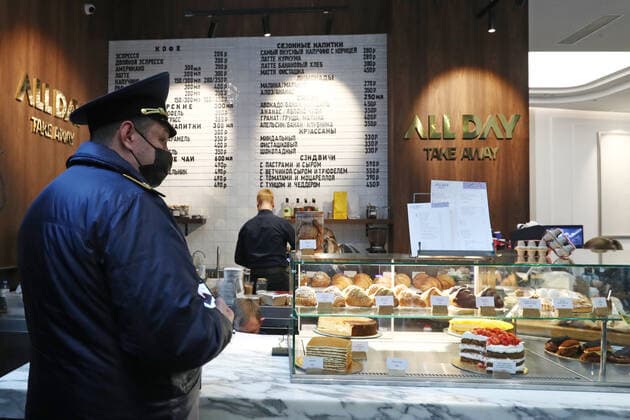 MOSCOW, RUSSIA - OCTOBER 29, 2021: An officer of Moscow s Association of Administrative and Technical Inspections checks compliance with sanitary and public health safety requirements at a cafe at the Moscow International Business Center amid the COVID-19 pandemic. Moscow has announced non-working days from October 28 to November 7 to prevent the spread of the novel coronavirus. Stanislav Krasilnikov TASS  TS11637C