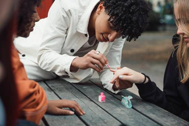 Male teenager applying nail polish to female friend at table Sweden, Stockholm, model released Copyright: xMaskotx , MA89957