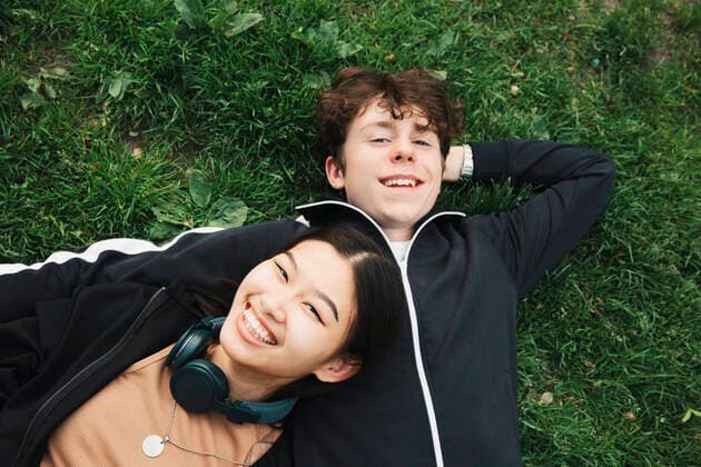 IMAGO Creative, Jahreszeit Herbst, Ferien Smiling male and female friends lying on grass Sweden, Stockholm, model released Copyright: xMaskotx , MA89971