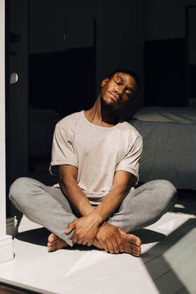 Mid adult man meditating in sunlight at home Sweden, Stockholm, model released, property released Copyright: xMaskotx , MA89988