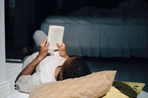 IMAGO Creative: Kulturelle Folgen der Pandemie: Gesundheitsbewußtsein und Alleinsein Man reading book while lying on floor in sunlight at home Sweden, Stockholm, model released, property released Copyright: xMaskotx , MA89989