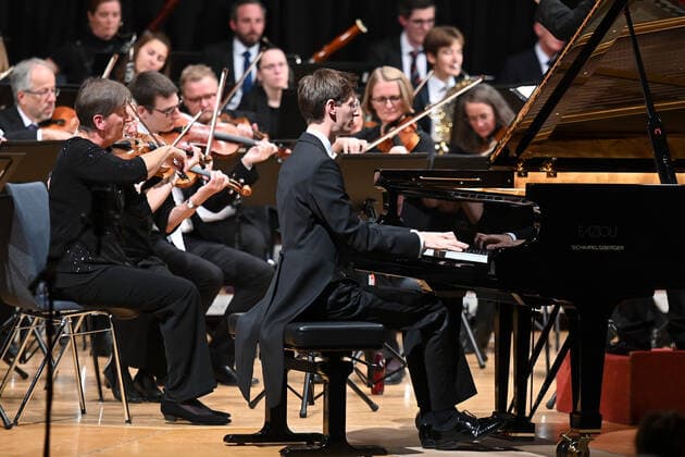 Concert of the orchestra of the Gesellschaft der Musikfreunde Gmunden, at the Toskana Kongress, as part of the Salzkammergut Festwochen in Gmunden, on 30 10 21 The picture shows the pianist Florian Feilmair playing, with violinists surrounding him 2021 Concert of the orchestra of the Gesellschaft der Musikfreunde Gmunden, at the Toskana Kongress, as par