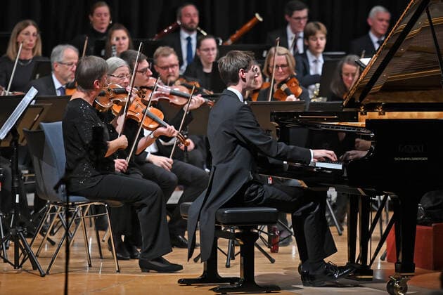 Concert of the orchestra of the Gesellschaft der Musikfreunde Gmunden, at the Toskana Kongress, as part of the Salzkammergut Festwochen in Gmunden, on 30 10 21 The picture shows the pianist Florian Feilmair playing, with violinists surrounding him 2021 Concert of the orchestra of the Gesellschaft der Musikfreunde Gmunden, at the Toskana Kongress, as par