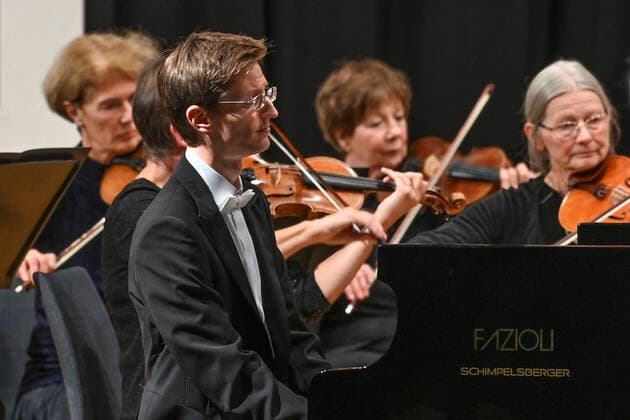 Concert of the orchestra of the Gesellschaft der Musikfreunde Gmunden, at the Toskana Kongress, as part of the Salzkammergut Festwochen in Gmunden, on 30 10 21 The picture shows the pianist Florian Feilmair playing, with violinists surrounding him 2021 Concert of the orchestra of the Gesellschaft der Musikfreunde Gmunden, at the Toskana Kongress, as