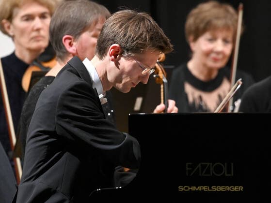 Concert of the orchestra of the Gesellschaft der Musikfreunde Gmunden, at the Toskana Kongress, as part of the Salzkammergut Festwochen in Gmunden, on 30 10 21 The picture shows the pianist Florian Feilmair playing, with musicians surrounding him 2021 Concert of the orchestra of the Gesellschaft der Musikfreunde Gmunden, at the Toskana Kongress, as