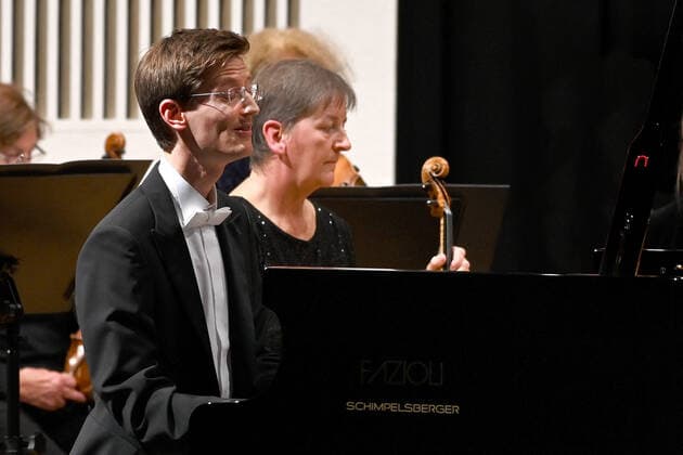 Concert of the orchestra of the Gesellschaft der Musikfreunde Gmunden, at the Toskana Kongress, as part of the Salzkammergut Festwochen in Gmunden, on 30 10 21 The picture shows the pianist Florian Feilmair playing, with musicians surrounding him 2021 Concert of the orchestra of the Gesellschaft der Musikfreunde Gmunden, at the Toskana Kongress, as