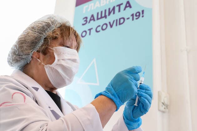 MOSCOW, RUSSIA â€“ NOVEMBER 1, 2021: A healthcare worker holds a syringe with a vaccine at a COVID-19 mobile vaccination site at the GUM department store. From October 28 to November 7, the Moscow authorities have introduced paid non-working days to limit the spread of the novel coronavirus disease (COVID-19). Shopping malls, entertainment establishments, fitness centres and non-essential retail stores will suspend their operation and cafes and restaurants will only provide takeaway and food delivery services during this time. Sergei Fadeichev TASS  TS116708