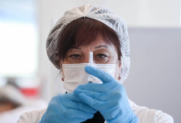 MOSCOW, RUSSIA â€“ NOVEMBER 1, 2021: A healthcare worker holds a syringe with a vaccine at a COVID-19 mobile vaccination site at the GUM department store. From October 28 to November 7, the Moscow authorities have introduced paid non-working days to limit the spread of the novel coronavirus disease (COVID-19). Shopping malls, entertainment establishments, fitness centres and non-essential retail stores will suspend their operation and cafes and restaurants will only provide takeaway and food delivery services during this time. Sergei Fadeichev TASS  TS116713