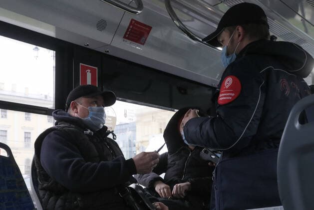 MOSCOW, RUSSIA - NOVEMBER 4, 2021: A tram ticket collector checks passengers and enforces the face mask requirement. Due to a surge in COVID-19 cases, the Moscow authorities has declared non-working days with pay from October 28 to November 7. Alexander Shcherbak TASS  TS116B43