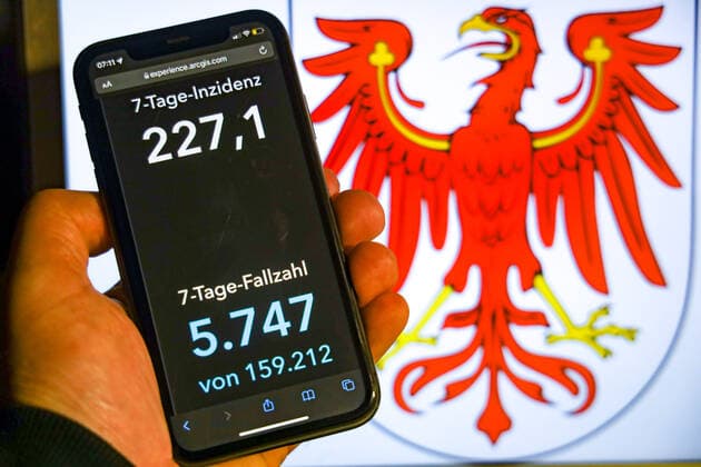 Coronavirus in Germany Covid 19 Dashboard of the Robert Koch Institute DEU, Germany, Brandenburg 07 11 2021 The 7-day incidence for the state Cases last 7 days 100 000 p.e. is displayed on an iPhone, with the state coat of arms in the background.
