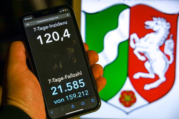 Coronavirus in Germany Covid 19 Dashboard of the Robert Koch Institute DEU, Germany, North Rhine Westphalia 07 11 2021 The 7-day incidence for the state Cases last 7 days 100 000 PE is displayed on an iPhone, with the state coat of arms in the background.