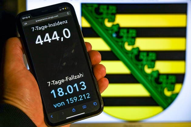 Coronavirus in Germany Covid 19 Dashboard of the Robert Koch Institute DEU, Germany, Saxony 07 11 2021 The 7-day incidence for the state Cases last 7 days 100 000 PE is displayed on an iPhone, with the state coat of arms in the background.