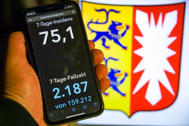 Coronavirus in Germany Covid 19 Dashboard of the Robert Koch Institute DEU, Germany, Schleswig Holstein 07 11 2021 The 7-day incidence for the state Cases last 7 days 100 000 PE is displayed on an iPhone, with the state coat of arms in the background.