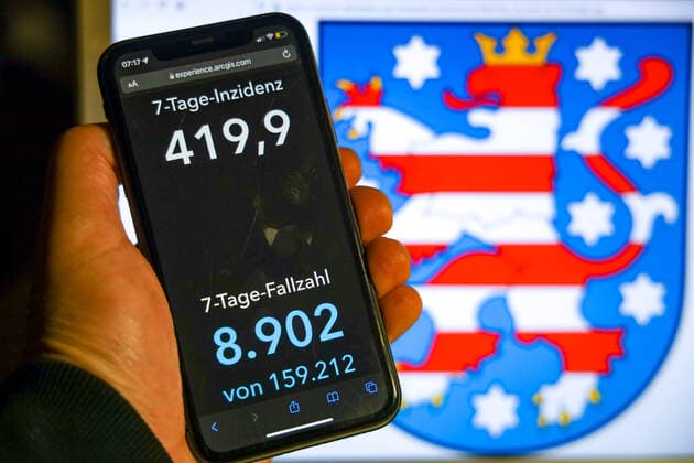 Coronavirus in Germany Covid 19 Dashboard of the Robert Koch Institute DEU, Germany, Thuringia 07 11 2021 The 7-day incidence for the state Cases last 7 days 100 000 PE is displayed on an iPhone, with the state coat of arms in the background.