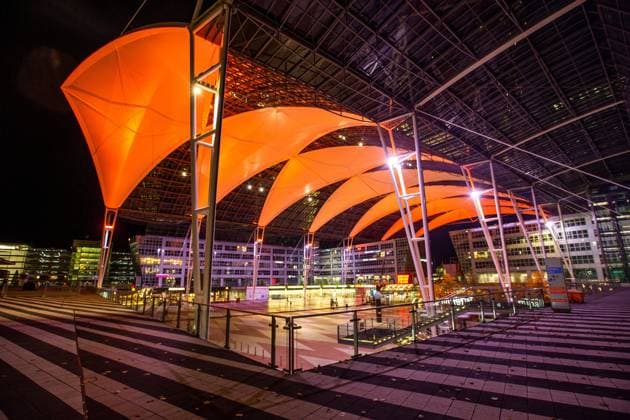 Flughafen Vorplatz zwischen Terminal 1 und Terminal 2 Gebäude Architektur Nachtaufnahme Stimmung Nachtstimmung Zebrastreifen Stahlstreben Stahlkonstruktion Kunstlicht oranges Dach auf dem Flughafen in München Datum: 08.11.2021 *** airport forecourt between terminal 1 and terminal 2 building architecture night shot mood night atmosphere zebra crossing steel struts steel construction artificial light orange roof at the airport in Munich Germany date 08 11 2021