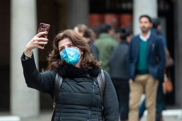 (211110) -- LONDON, Nov. 10, 2021 -- A woman wearing a mask takes a selfie in Covent Garden in London, Britain, on Nov. 9, 2021. Britain on Tuesday registered 33,117 new COVID-19 infections and 262 coronavirus related deaths, bringing the total loss of lives to 142,124, according to the latest official figures. (Photo by Xinhua) BRITAIN-COVID-19-CASES StephenxChung 