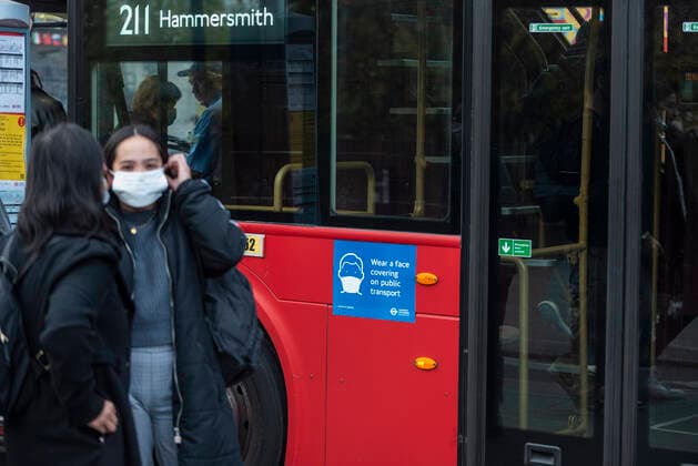 (211110) -- LONDON, Nov. 10, 2021 -- A woman puts on a facemask at a bus stop in London, Britain, on Nov. 9, 2021. Britain on Tuesday registered 33,117 new COVID-19 infections and 262 coronavirus related deaths, bringing the total loss of lives to 142,124, according to the latest official figures. (Photo by Xinhua) BRITAIN-COVID-19-CASES StephenxChung 