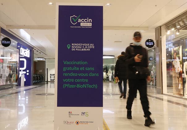 (211110) -- PARIS, Nov. 10, 2021 -- A customer walks past a sign indicating a COVID-19 vaccination center inside a shopping mall in Levallois-Perret near Paris, France, Nov. 9, 2021. French President Emmanuel Macron announced Tuesday evening to postpone the pre-decided easing of anti-COVID-19 measures, since France is undergoing the fifth wave of the pandemic. People over 65 years old and the most vulnerable ones will have to get a booster dose in order to validate their health pass from Dec. 15. ) FRANCE-PARIS-COVID-19-BOOSTER SHOT GaoxJing 