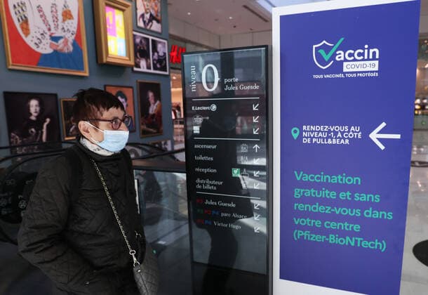 (211110) -- PARIS, Nov. 10, 2021 -- A customer walks past a sign indicating a COVID-19 vaccination center inside a shopping mall in Levallois-Perret near Paris, France, Nov. 9, 2021. French President Emmanuel Macron announced Tuesday evening to postpone the pre-decided easing of anti-COVID-19 measures, since France is undergoing the fifth wave of the pandemic. People over 65 years old and the most vulnerable ones will have to get a booster dose in order to validate their health pass from Dec. 15. ) FRANCE-PARIS-COVID-19-BOOSTER SHOT GaoxJing 