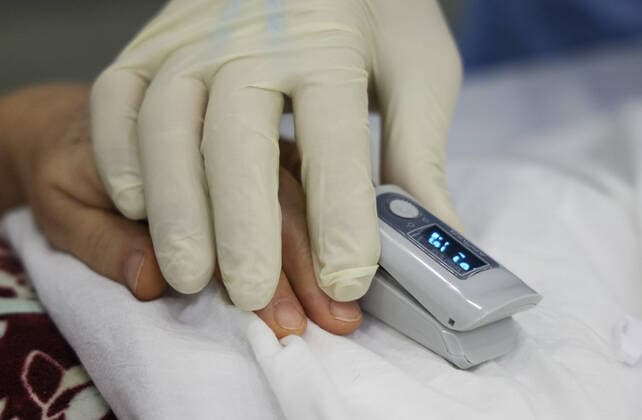 Coronavirus in Russland, EindrÃ¼cke aus provisorischer Covid-19-Einrichtung in Moskau MOSCOW REGION, RUSSIA - NOVEMBER 12, 2021: A medical worker measures a patient s oxygen saturation level in the red zone of a temporary COVID-19 facility at the Patriot Convention and Exhibition Center of the Russian Armed Forces in the town of Kubinka near Moscow. Moscow Region is listed third after Moscow and St Petersburg with the highest number of COVID-19 cases in Russia; over 1,000 people are hospitalized in the region daily. Gavriil Grigorov TASS  TS117A58