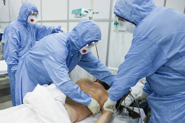 Coronavirus in Russland, EindrÃ¼cke aus provisorischer Covid-19-Einrichtung in Moskau MOSCOW REGION, RUSSIA - NOVEMBER 12, 2021: Medical workers attend a patient in the red zone of a temporary COVID-19 facility at the Patriot Convention and Exhibition Center of the Russian Armed Forces in the town of Kubinka near Moscow. Moscow Region is listed third after Moscow and St Petersburg with the highest number of COVID-19 cases in Russia; over 1,000 people are hospitalized in the region daily. Gavriil Grigorov TASS  TS117A5B