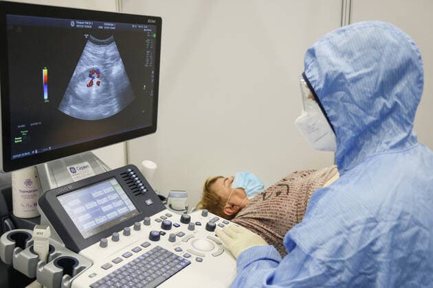 Coronavirus in Russland, EindrÃ¼cke aus provisorischer Covid-19-Einrichtung in Moskau MOSCOW REGION, RUSSIA - NOVEMBER 12, 2021: A medical worker does an ultrasound to a patient in the red zone of a temporary COVID-19 facility at the Patriot Convention and Exhibition Center of the Russian Armed Forces in the town of Kubinka near Moscow. Moscow Region is listed third after Moscow and St Petersburg with the highest number of COVID-19 cases in Russia; over 1,000 people are hospitalized in the region daily. Gavriil Grigorov TASS  TS117A5F