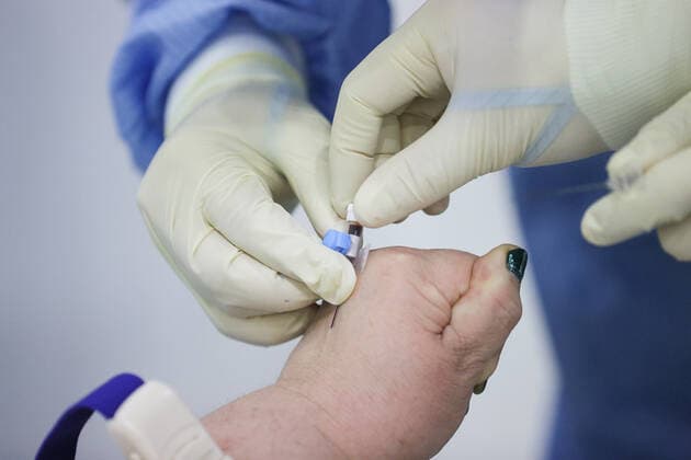 Coronavirus in Russland, EindrÃ¼cke aus provisorischer Covid-19-Einrichtung in Moskau MOSCOW REGION, RUSSIA - NOVEMBER 12, 2021: A medical worker takes a blood sample from a patient in the red zone of a temporary COVID-19 facility at the Patriot Convention and Exhibition Center of the Russian Armed Forces in the town of Kubinka near Moscow. Moscow Region is listed third after Moscow and St Petersburg with the highest number of COVID-19 cases in Russia; over 1,000 people are hospitalized in the region daily. Gavriil Grigorov TASS  TS117A6F