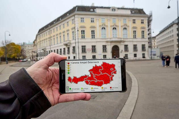 - Wien 12.11.2021 - Coronavirus Krise - Kurz vor Beginn der Wintersaison stuft Deutschland Österreich seit heute wieder als Hochrisikogebiet ein. Das teilte Deutschlands Gesundheitsminister Jens Spahn (CDU) heute mit. Personen, die weder geimpft noch genesen sind, müssen nach einem Aufenthalt in Österreich nach der Einreise in Deutschland in zehntägige Quarantäne. Die stark steigenden Infektionszahlen in Österreich sind mit ein Grund für die Reisewarnung. PHOTO: Die Corona-Ampel steht auf Rot für ganz Österreich. Das Bundeskanzleramt (im Hintergrund) wird am Sonntag einen bundesweiten Lockdown für Ungeimpfte verkünden. Vienna, Austria - Coronavirus Crisis - Shortly before the start of the winter season, Germany has again classified Au 