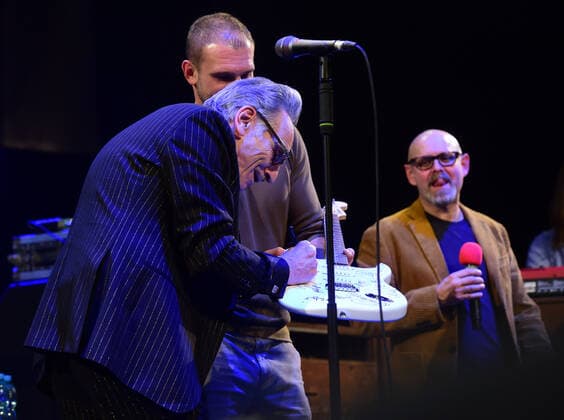 Singer Rick Estrin, left, of Rick Estrin and The Nightcats music band signs a guitar that will go to the auction, during the 25th Blues Alive, blues & roots festival, on November 12, 2021, in Sumperk, Czech Republic. (CTKxPhoto LudekxPerina) CTKPhotoP2021111210536  LPE 035