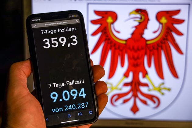 Coronavirus in Germany Covid 19 Dashboard of the Robert Koch Institute DEU, Germany, Brandenburg 14 11 2021 The 7-day incidence for the state Cases last 7 days 100 000 p.e. is displayed on an iPhone, with the states coat of arms in the background
