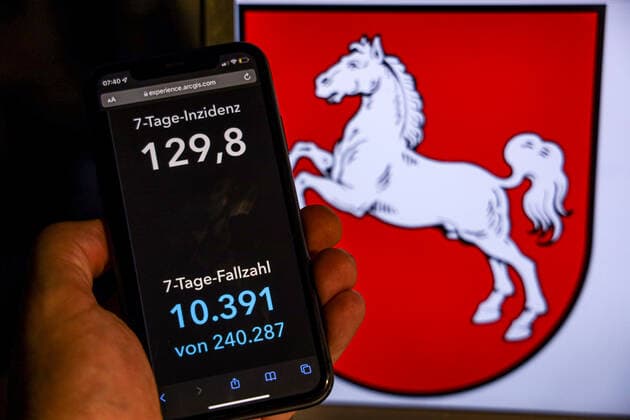 Coronavirus in Germany Covid 19 Dashboard of the Robert Koch Institute DEU, Germany, Lower Saxony 14 11 2021 The 7-day incidence for the state Cases last 7 days 100 000 p.e. is displayed on an iPhone, with the states coat of arms in the background