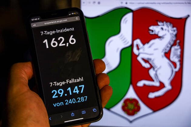 Coronavirus in Germany Covid 19 Dashboard of the Robert Koch Institute DEU, Germany, Northern Ireland Westphalia 14 11 2021 The 7-day incidence for the state Cases last 7 days 100 000 p.e. is displayed on an iPhone, with the states coat of arms in the background