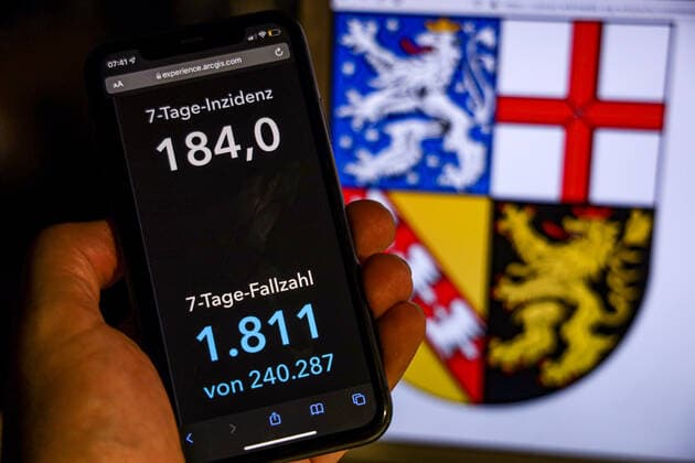 Coronavirus in Germany Covid 19 Dashboard of the Robert Koch Institute DEU, Germany, Saarland 14 11 2021 The 7-day incidence for the state Cases last 7 days 100 000 PE is displayed on an iPhone, with the state coat of arms in the background.