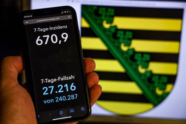 Coronavirus in Germany Covid 19 Dashboard of the Robert Koch Institute DEU, Germany, Saxony 14 11 2021 The 7-day incidence for the state Cases last 7 days 100 000 PE is displayed on an iPhone, with the state coat of arms in the background.