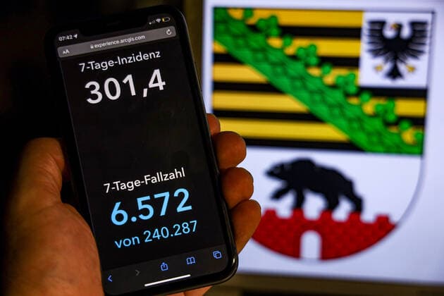 Coronavirus in Germany Covid 19 Dashboard of the Robert Koch Institute DEU, Germany, Saxony Anhalt 14 11 2021 The 7-day incidence for the state Cases last 7 days 100 000 PE is displayed on an iPhone, with the state coat of arms in the background.
